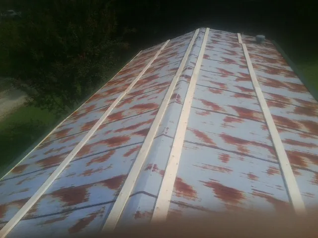Rusted metal roof panels with new wood purlins before replacement — Storm Damage Roof Repair in Burgoon by Roofing Brothers